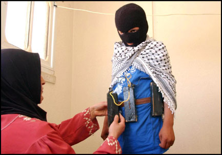 Mohammed helps her 12-year-old son Abu Ali with a toy suicide-bomber belt he fashioned. "I hope to be a martyr ... I hope when I get 14 or 15 to explode myself." His mother is proud of her son: "God gave him to me to protect and defend our homeland." Photo Maya Alleruzo