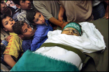  Thirteen-year-old Ezzedime Al Hillou is mourned by playmates at a Gaza City mosque in May, 2002. Ezzedime was shot by Israeli troops while playing near his home at the Kharny Crossing checkpoint into the Gaza Strip and died when no ambulance could reach him. He wears a Hamas headband. Photo: Maya Alleruzzo